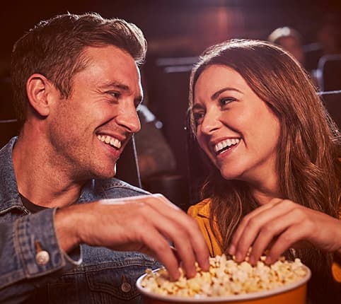 Couple sharing popcorn at a show