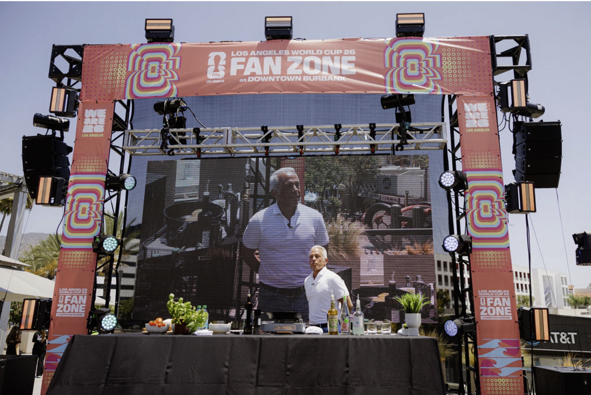 Chef Geoffrey Zakarian gives a live cooking demonstration on the Fan Zone stage, shown on a large LED screen